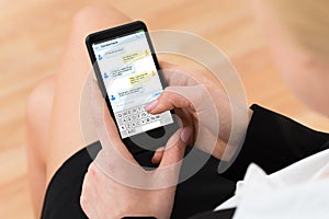 Woman Sending Text Message On Her Mobile Phone