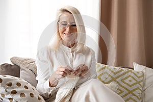 Woman Senior Adult Knitting Concept - Elderly blond woman holding knitting needles