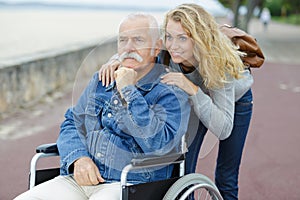woman and senior man in wheelchair photo