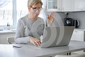 Woman senior work at a laptop close-up using modern technology in everyday life at home