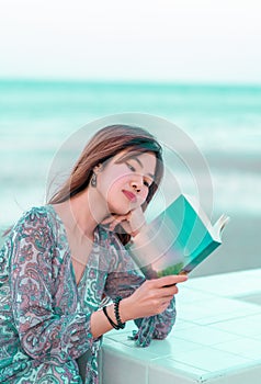 Woman with Sensuality is reading a book on a beach for relaxation concept