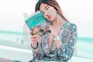 Woman with Sensuality is reading a book on a beach for relaxation concept