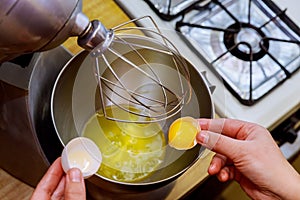 A woman separates egg white from yolk to make a sponge cake