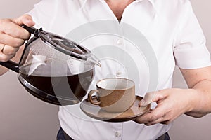 Woman serves a cup of coffee