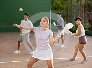 Woman serving ball during frontenis game outdoors photo