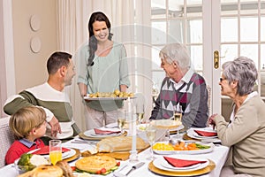 Woman serving christmas dinner to her family