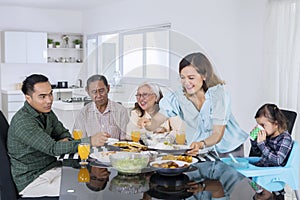 Woman serving food for her multi generation family