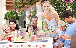 Woman Serving Meal To Two Families