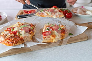 Woman serving a piece of pimped up pizza on a spatula in the kitchen