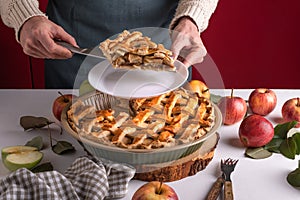 Woman serving a slice of apple pie on a plate, ready to eat