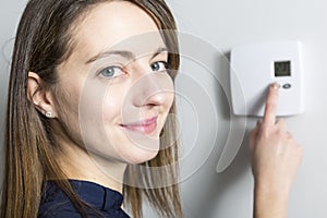 Woman set the thermostat at home