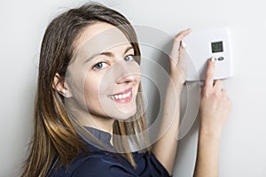 Woman set the thermostat at home