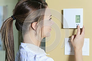 Woman set the thermostat at house