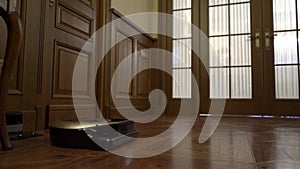 Woman sets the program to the robot vacuum cleaner. Smart design technology and robotic vacuum cleaner on floor