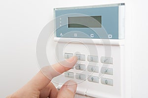 Woman Setting Control Panel On Home Security System