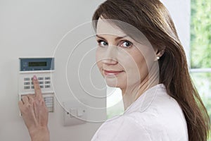 Woman Setting Control Panel On Home Security System
