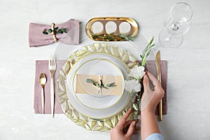 Woman setting table for festive dinner