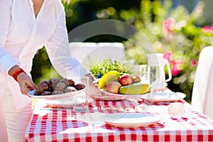 Woman setting table outdoors. Garden summer fun