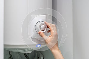 Woman setting temperature program on electric boiler