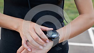 Woman setting up the fitness smartwatch for running. Sporty girl checking watch device, close up