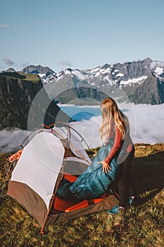 Woman setting up tent camping gear in mountains travel lifestyle vacations outdoor, traveler girl hiking in Norway
