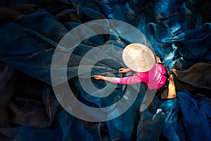 Woman sew the fishnet. Fisherman Repairs Fishing Net. Needle with thread in fisherman hand repairing net in home