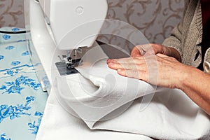 Woman sews fabric on a sewing machine