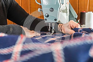 woman sews on a sewing machine, no face.