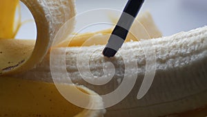 Woman sexually touching with a brush of purified banana, macro close up view