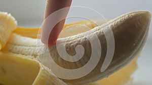 Woman sexually touching with a finger of purified banana, macro close up view