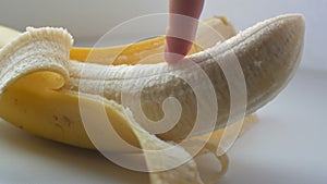 Woman sexually touching with a finger of purified banana, macro close up view