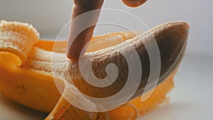 Woman sexually touching with a finger of purified banana, macro close up view