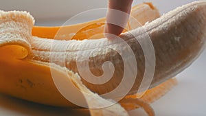 Woman sexually touching with a finger of purified banana, macro close up view