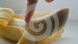 Woman sexually touching with a finger of purified banana, macro close up view