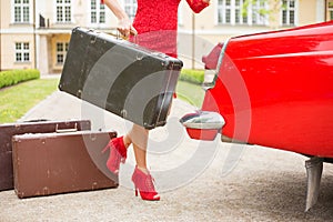 Woman with legs holding a vintage suitcase