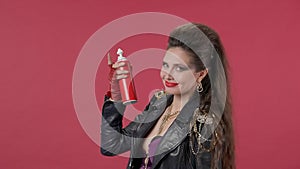 A woman shakes the can of whipped cream well, then squeezes the yummy into her mouth, winks. Portrait of a woman on a