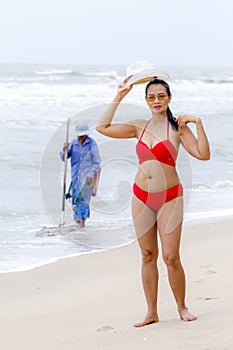 Woman shape with red bikini and hat on beach