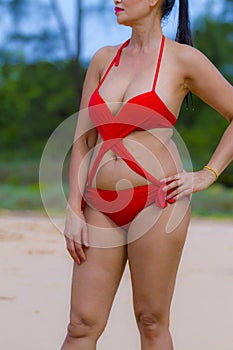 Woman with shape sex symbol in sunshine on beach