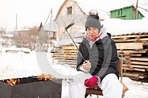 A woman with a shashlik on a shampoo, in winter