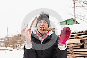 A woman with a shashlik on a shampoo, in winter