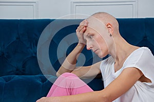 Woman with shaved head sit sadly struggle of chemo side effects