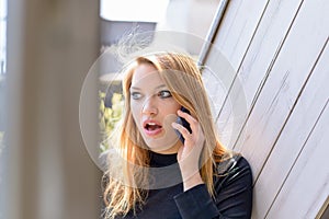 Woman shocked during conversation on mobile phone