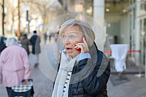 Woman shocked talking by the phone