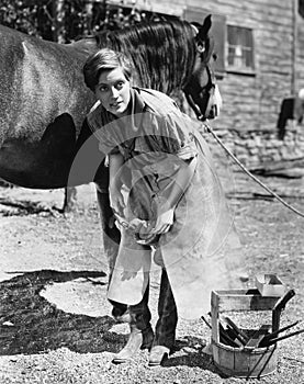 Woman shoeing horse