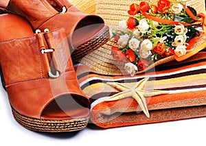 Woman shoes decorated with starfish, towels, beach hat