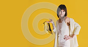 Woman with shoes on yellow background. Copy space.