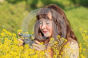Woman shooting flowers on the meadow.