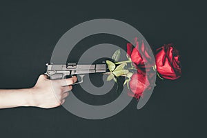 Woman shooting gun with red roses