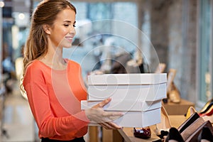 Woman or shop assistant with shoe boxes at store