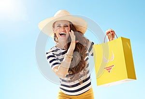 Woman with shopping bag with bikini telling exciting news